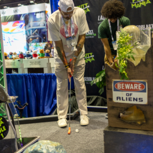 Two men putting with Putt Mania equipment at IAAPA 2023.
