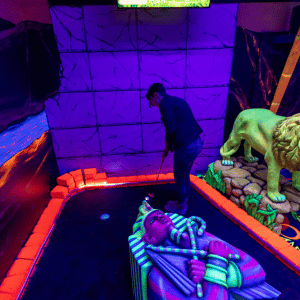 Woman putting on Egyptian theme indoor mini golf hole with Putt Mania.