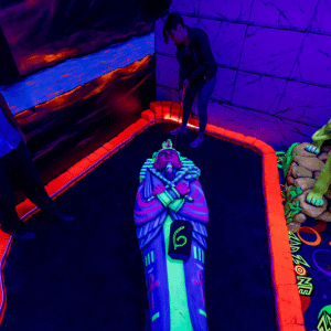 Woman putting on Egyptian theme indoor mini golf hole with Putt Mania.