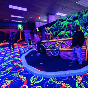 Two people on a shipwreck theme mini golf hole with Putt Mania.