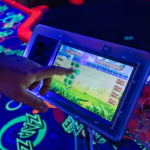 Finger touching the touchscreen on a Putt Mania hole marker.