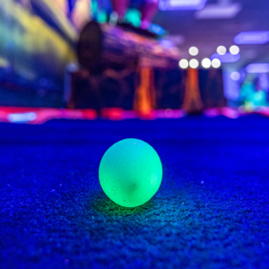 Green illuminated Putt Mania golf ball on glow golf course