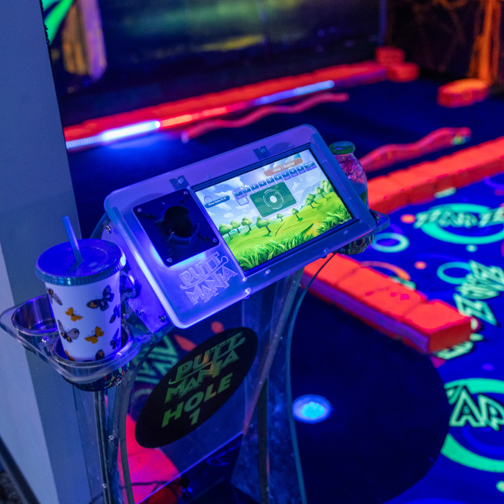 Put Mania hole marker on a golf course with beverages in the cup holders.