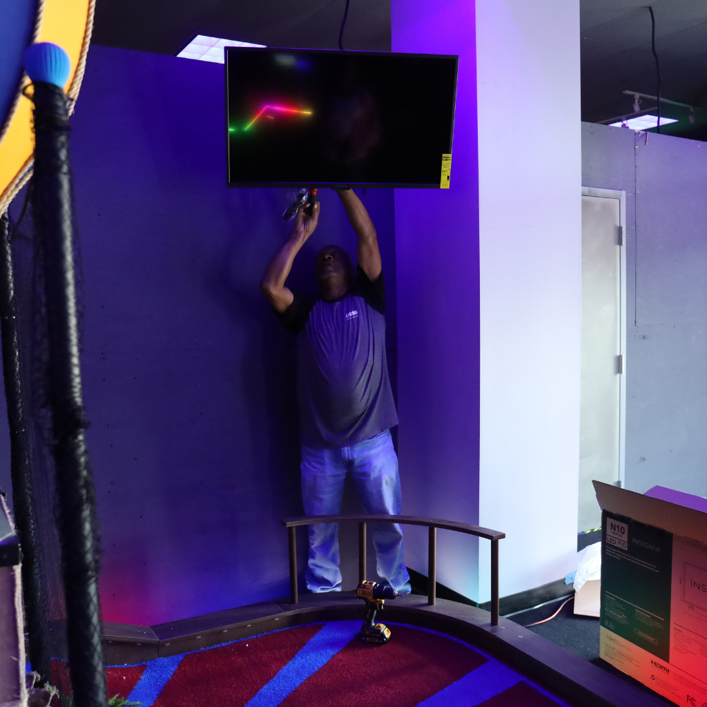 Man installing a mounted television on a wal