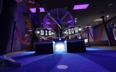 Golf hole with a ferris wheel prop and an illuminated sign that says "Big Show".