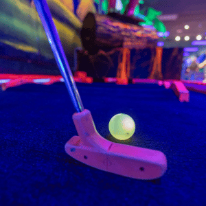 Putter about to hit a Putt Mania golf ball on an indoor mini golf course